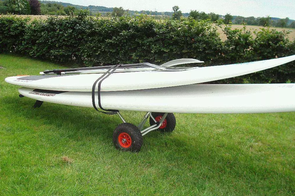 ECKLA Surfrolly im Einsatz – Transport von Surfboard auf weichem Untergrund mit Luftbereifung für sanfte Fahrt.